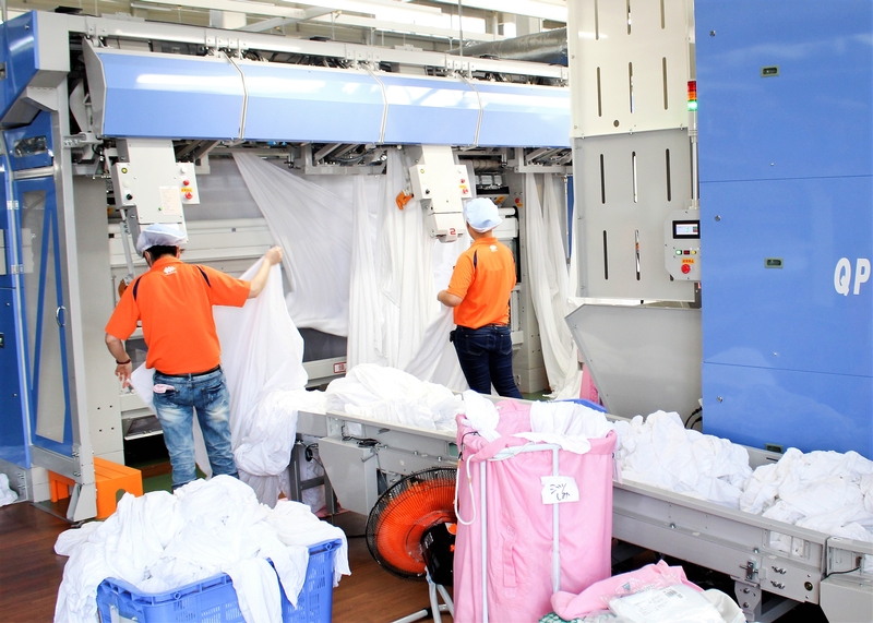 クリーニング工場で機械に衣類のセット